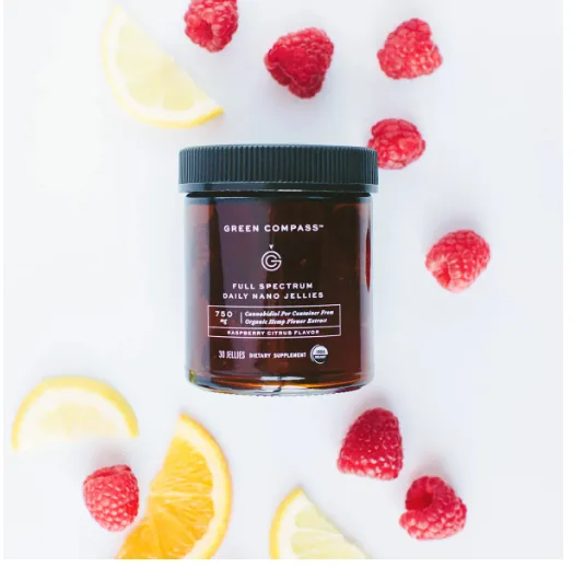 A jar of Green Compass full spectrum daily hemp jellies with raspberries and citrus slices