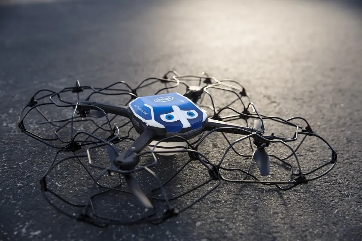 Caged quadcopter drone resting on asphalt